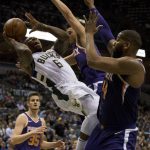 Milwaukee Bucks guard Eric Bledsoe, center, is defended by Phoenix Suns center Greg Monroe, right, and Devin Booker, center, during the first half of an NBA basketball game Monday, Jan. 22, 2018, in Milwaukee. (AP Photo/Darren Hauck)