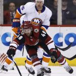 Arizona Coyotes left wing Jordan Martinook (48) tries to control the puck in front of New York Islanders left wing Jason Chimera (25) during the first period of an NHL hockey game, Monday, Jan. 22, 2018, in Glendale, Ariz. (AP Photo/Ross D. Franklin)