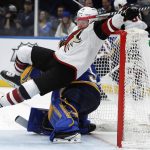 Arizona Coyotes' Max Domi, top, falls over St. Louis Blues goaltender Jake Allen during the third period of an NHL hockey game Saturday, Jan. 20, 2018, in St. Louis. (AP Photo/Jeff Roberson)