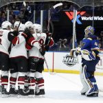 Arizona Coyotes' Christian Dvorak is surrounded by teammates after scoring past St. Louis Blues goaltender Carter Hutton, right, during the first period of an NHL hockey game Saturday, Jan. 20, 2018, in St. Louis. (AP Photo/Jeff Roberson)
