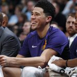 Phoenix Suns guard Devin Booker, center, laughs as fans heckle him and Phoenix Suns guard Isaiah Canaan, right, during the second half of the team's NBA basketball game against the Denver Nuggets on Friday, Jan. 19, 2018, in Denver. Phoenix won 108-100. (AP Photo/David Zalubowski)