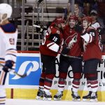 Arizona Coyotes center Brad Richardson (15) celebrates his goal against the Edmonton Oilers with Coyotes left wing Jordan Martinook, second from right, and center Nick Cousins (25) as Oilers left wing Drake Caggiula (91) skates past during the first period of an NHL hockey game, Friday, Jan. 12, 2018, in Glendale, Ariz. (AP Photo/Ross D. Franklin)