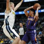 Denver Nuggets center Mason Plumlee, left, defends Phoenix Suns guard Devin Booker, who looks to pass the ball during the second half of an NBA basketball game Wednesday, Jan. 3, 2018, in Denver. The Nuggets won 134-111. (AP Photo/David Zalubowski)