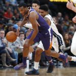 Phoenix Suns forward TJ Warren, front, picks up a loose ball in front of Denver Nuggets guard Gary Harris in the second half of an NBA basketball game Wednesday, Jan. 3, 2018, in Denver. The Nuggets won 134-111. (AP Photo/David Zalubowski)