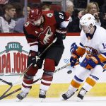 Arizona Coyotes center Derek Stepan (21) battles with New York Islanders defenseman Thomas Hickey (14) for control of the puck during the first period of an NHL hockey game, Monday, Jan. 22, 2018, in Glendale, Ariz. (AP Photo/Ross D. Franklin)