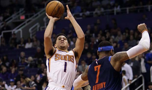 Phoenix Suns guard Devin Booker (1) shoots over Oklahoma City Thunder forward Carmelo Anthony in th...