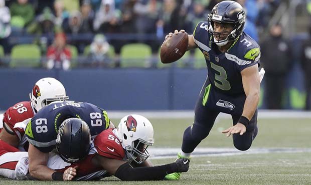 Seattle Seahawks quarterback Russell Wilson, right, is tripped by Arizona Cardinals outside linebac...
