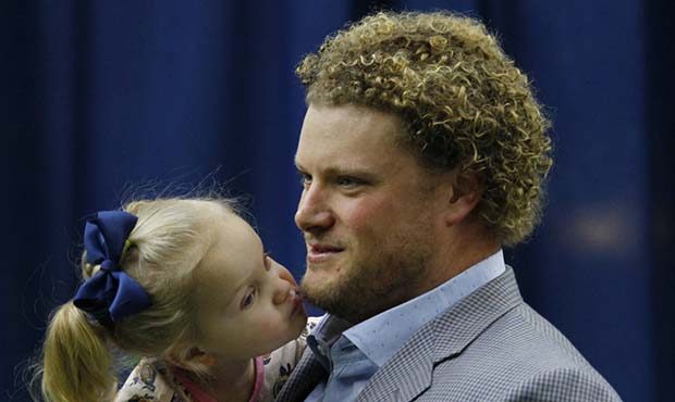 Buffalo Bills center Eric Wood is kissed by daughter Grace following a press conference announcing ...