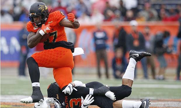 North Squad running back Kalen Ballage, of Arizona State, avoids the tackle against South Squad's Q...