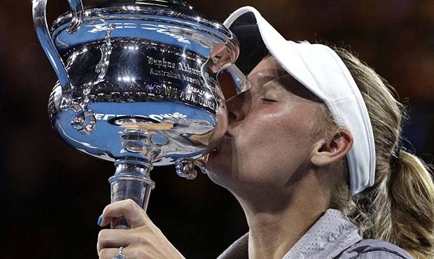 Denmark's Caroline Wozniacki kisses her trophy after defeating Romania's Simona Halep in the women'...