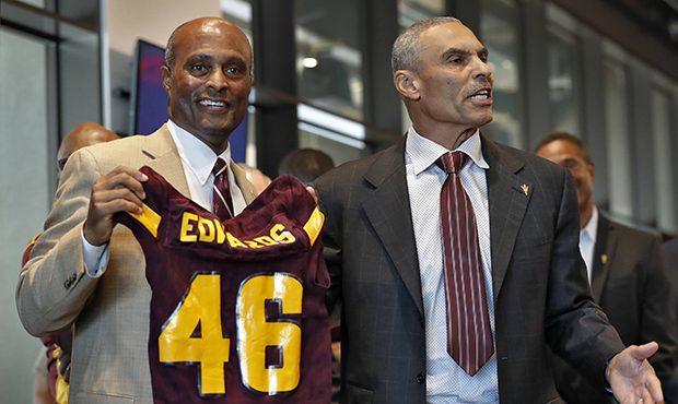 Newly appointed Arizona State University NCAA college football head coach Herman Edwards, right, ho...
