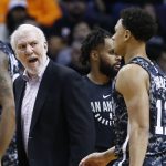 San Antonio Spurs coach Gregg Popovich, left, talks with guard Bryn Forbes (11) during a timeout in the first half of the team's NBA basketball game against the Phoenix Suns on Wednesday, Feb. 7, 2018, in Phoenix. The Spurs defeated the Suns 129-81. (AP Photo/Ross D. Franklin)
