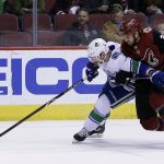 Vancouver Canucks left wing Sven Baertschi shields the puck from Arizona Coyotes center Zac Rinaldo (34) in the first period during an NHL hockey game, Sunday, Feb. 25, 2018, in Glendale, Ariz. (AP Photo/Rick Scuteri)