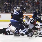 Winnipeg Jets' Ben Chiarot (7) can't settle the bouncing puck as he tries to get a shot on Arizona Coyotes' goaltender Antti Raanta (32) with Alex Goligoski (33) sprawled in front of the net during second period NHL hockey action in Winnipeg, Manitoba Tuesday, Feb. 6, 2018. (Trevor Hagan/The Canadian Press via AP)