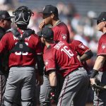 Arizona Diamondbacks' Taijuan Walker, center, speaks with pitching coach Mike Butcher, left, during the first inning of a spring training baseball game against the San Francisco Giants on Tuesday, Feb. 27, 2018, in Scottsdale, Ariz. (AP Photo/Ben Margot)