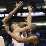 Phoenix Suns center Alex Len, center, tries to shoot the ball between the defense of Charlotte Hornets' Michael Carter-Williams, left, and Nicolas Batum during the second half of an NBA basketball game Sunday, Feb. 4, 2018, in Phoenix. (AP Photo/Ralph Freso)