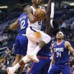 Phoenix Suns guard Elfrid Payton (2) drives to he basket through the defense of Los Angeles Clippers' Tyrone Wallace (12) and Montrezl Harrell (5) during the second half of an NBA basketball game Friday, Feb. 23, 2018, in Phoenix. (AP Photo/Ralph Freso)