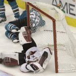 Arizona Coyotes goaltender Scott Wedgewood, bottom, grabs his helmet after being hit during the third period of the team's NHL hockey game against the San Jose Sharks in San Jose, Calif., Tuesday, Feb. 13, 2018. Wedgewood left the game after the play. (AP Photo/Jeff Chiu)