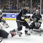 Arizona Coyotes center Christian Dvorak (18) and Los Angeles Kings defenseman Christian Folin (5) and goalie Darcy Kuemper (35) scramble in front of the goal during the first period of an NHL hockey game in Los Angeles on Saturday, Feb. 3, 2018. (AP Photo/Reed Saxon)