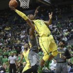 Oregon's MiKyle McIntosh, center, shoots between Arizona State's De'Quon Lake, left, and Remy Martin during the first half of an NCAA college basketball game Thursday, Feb. 22, 2018, in Eugene, Ore. (AP Photo/Chris Pietsch)
