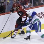 Arizona Coyotes left wing Brendan Perlini (11) and Vancouver Canucks defenseman Troy Stecher battle for the puck in the second period during an NHL hockey game, Sunday, Feb. 25, 2018, in Glendale, Ariz. (AP Photo/Rick Scuteri)