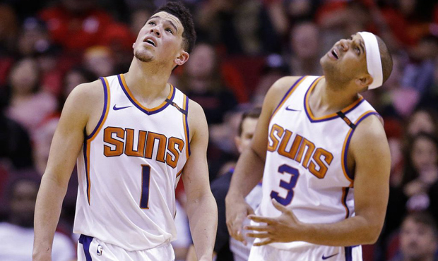 Phoenix Suns guard Devin Booker (1) and Jared Dudley look at the video screen after a foul was call...