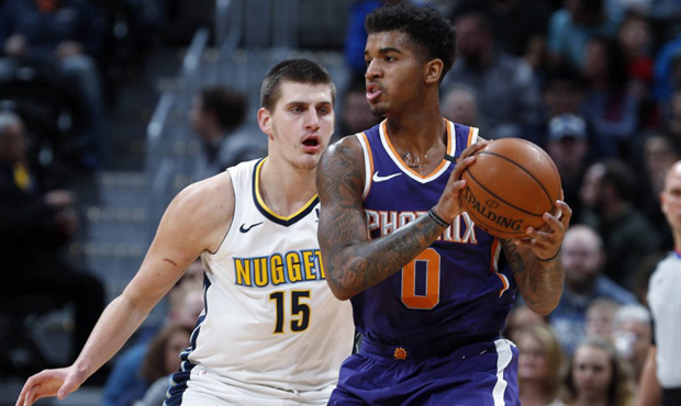Phoenix Suns forward Marquese Chriss, front, looks to pass the ball as Denver Nuggets center Nikola...