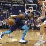 Charlotte Hornets guard Kemba Walker, left, drives to the basket as Phoenix Suns' Dragan Bender defends during the first half of an NBA basketball game Saturday, Feb. 4, 2018, in Phoenix. (AP Photo/Ralph Freso)