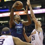 Charlotte Hornets center Dwight Howard (12) drives to the basket through the defense of Phoenix Suns' Alex Len (21) and Jared Dudley (8) during the first half of an NBA basketball game Saturday, Feb. 4, 2018, in Phoenix. (AP Photo/Ralph Freso)