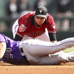 Colorado Rockies' Ryan McMahon slides in safe with a double past the tag of Arizona Diamondbacks shortstop Nick Ahmed during the fifth inning a spring training baseball game on Wednesday, Feb. 28, 2018, in Scottsdale, Ariz. (AP Photo/Ben Margot)
