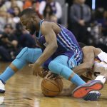 Charlotte Hornets guard Kemba Walker, left, and Phoenix Suns' T.J. Warren battle for the ball during the first half of an NBA basketball game Sunday, Feb. 4, 2018, in Phoenix. (AP Photo/Ralph Freso)
            