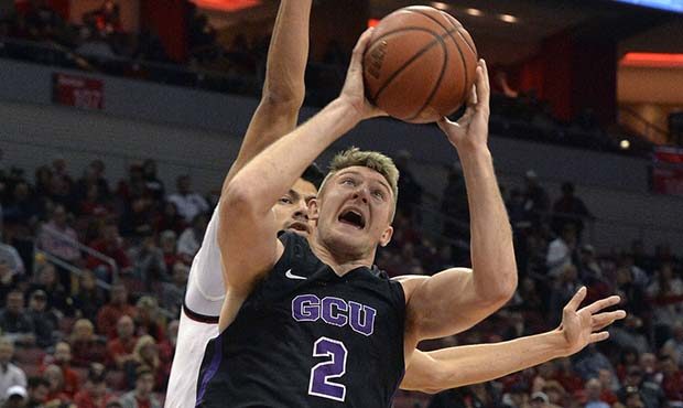 Grand Canyon guard Joshua Braun (2) goes in for a layup around the defense of Louisville forward An...