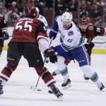 Vancouver Canucks left wing Daniel Sedin (22) carries the puck in front of Arizona Coyotes defenseman Jason Demers (55) in the first period during an NHL hockey game, Sunday, Feb. 25, 2018, in Glendale, Ariz. (AP Photo/Rick Scuteri)