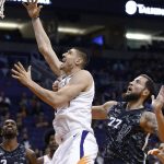 Phoenix Suns center Alex Len, left, beats San Antonio Spurs center Joffrey Lauvergne (77) to the basket for a score during the second half of an NBA basketball game Wednesday, Feb. 7, 2018, in Phoenix. The Spurs defeated the Suns 129-81. (AP Photo/Ross D. Franklin)