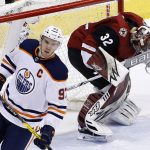 Arizona Coyotes goaltender Antti Raanta (32) celebrates a win as time expires as Edmonton Oilers center Connor McDavid (97) skates past during the third period of an NHL hockey game Saturday, Feb. 17, 2018, in Glendale, Ariz. (AP Photo/Ross D. Franklin)