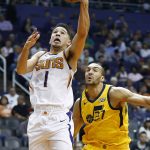 Phoenix Suns guard Devin Booker (1) drives past Utah Jazz center Rudy Gobert (27) to score during the second half of an NBA basketball game, Friday, Feb. 2, 2018, in Phoenix. (AP Photo/Ross D. Franklin)