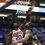 San Antonio Spurs forward LaMarcus Aldridge, middle, scores over Phoenix Suns forward Josh Jackson (20) and guard Troy Daniels, right, during the first half of an NBA basketball game Wednesday, Feb. 7, 2018, in Phoenix. (AP Photo/Ross D. Franklin)