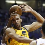 Utah Jazz center Rudy Gobert, middle, gets fouled by Phoenix Suns guard Troy Daniels, rear, during the first half of an NBA basketball gam  Friday, Feb. 2, 2018, in Phoenix. (AP Photo/Ross D. Franklin)