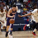 Phoenix Suns guard Devin Booker (1) and New Orleans Pelicans forward Anthony Davis (23) chase the ball in the second half of an NBA basketball game in New Orleans, Monday, Feb. 26, 2018. (AP Photo/Gerald Herbert)