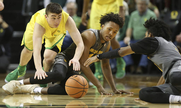 Oregon's Payton Pritchard, left, and Arizona State's Kimani Lawrence and Remy Martin, right, go the...