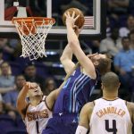 Charlotte Hornets center Cody Zeller (40) is fouled by Phoenix Suns' Devin Booker (1) as he drives to the basket during the second half of an NBA basketball game Sunday, Feb. 4, 2018, in Phoenix. (AP Photo/Ralph Freso)