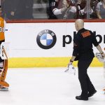 Philadelphia Flyers goaltender Brian Elliott (37) is helped off the ice due to injury as Flyers goaltender Michal Neuvirth (30) looks on before replacing him during a shootout of an NHL hockey game against the Arizona Coyotes, Saturday, Feb. 10, 2018, in Glendale, Ariz. (AP Photo/Ross D. Franklin)