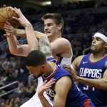 Phoenix Suns forward Dragan Bender, top left, vies for a rebound with Los Angeles Clippers' Austin Rivers, bottom, and Tobias Harris during the second half of an NBA basketball game Friday, Feb. 23, 2018, in Phoenix. The Clippers defeated the Suns 128-117. (AP Photo/Ralph Freso)