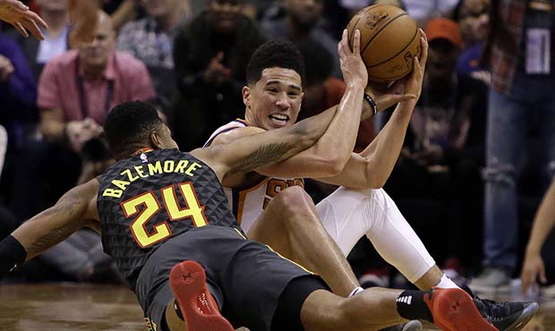 Phoenix Suns guard Devin Booker (1) and Atlanta Hawks guard Kent Bazemore vie for a loose ball in t...