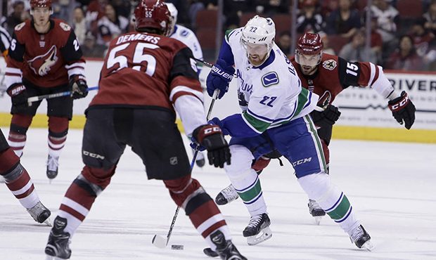 Vancouver Canucks left wing Daniel Sedin (22) carries the puck in front of Arizona Coyotes defensem...