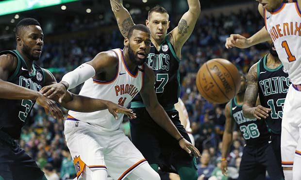 Phoenix Suns' Greg Monroe (14) and Devin Booker (1) battle for a loose ball with Boston Celtics' Se...