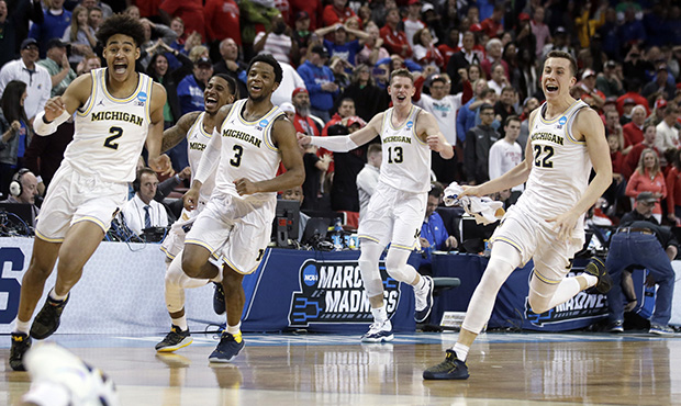 Michigan guard Jordan Poole (2) leads the team in celebration after his game-winning basket in an N...