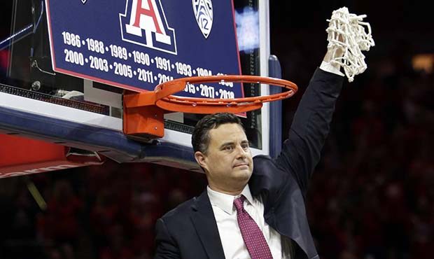 Arizona coach Sean Miller holds up the net after Arizona won the Pac-12 regular-season title, follo...