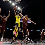 Michigan guard Muhammad-Ali Abdur-Rahkman (12) drives to the basket between Loyola-Chicago's Donte Ingram, left, and Ben Richardson during the second half in the semifinals of the Final Four NCAA college basketball tournament, Saturday, March 31, 2018, in San Antonio. (AP Photo/David J. Phillip)