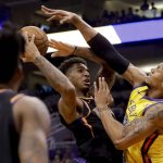 Phoenix Suns forward Marquese Chriss tries to shoot over Golden State Warriors forward David West during the second half of an NBA basketball game in Phoenix, Saturday, March 17, 2018. (AP Photo/Chris Carlson)